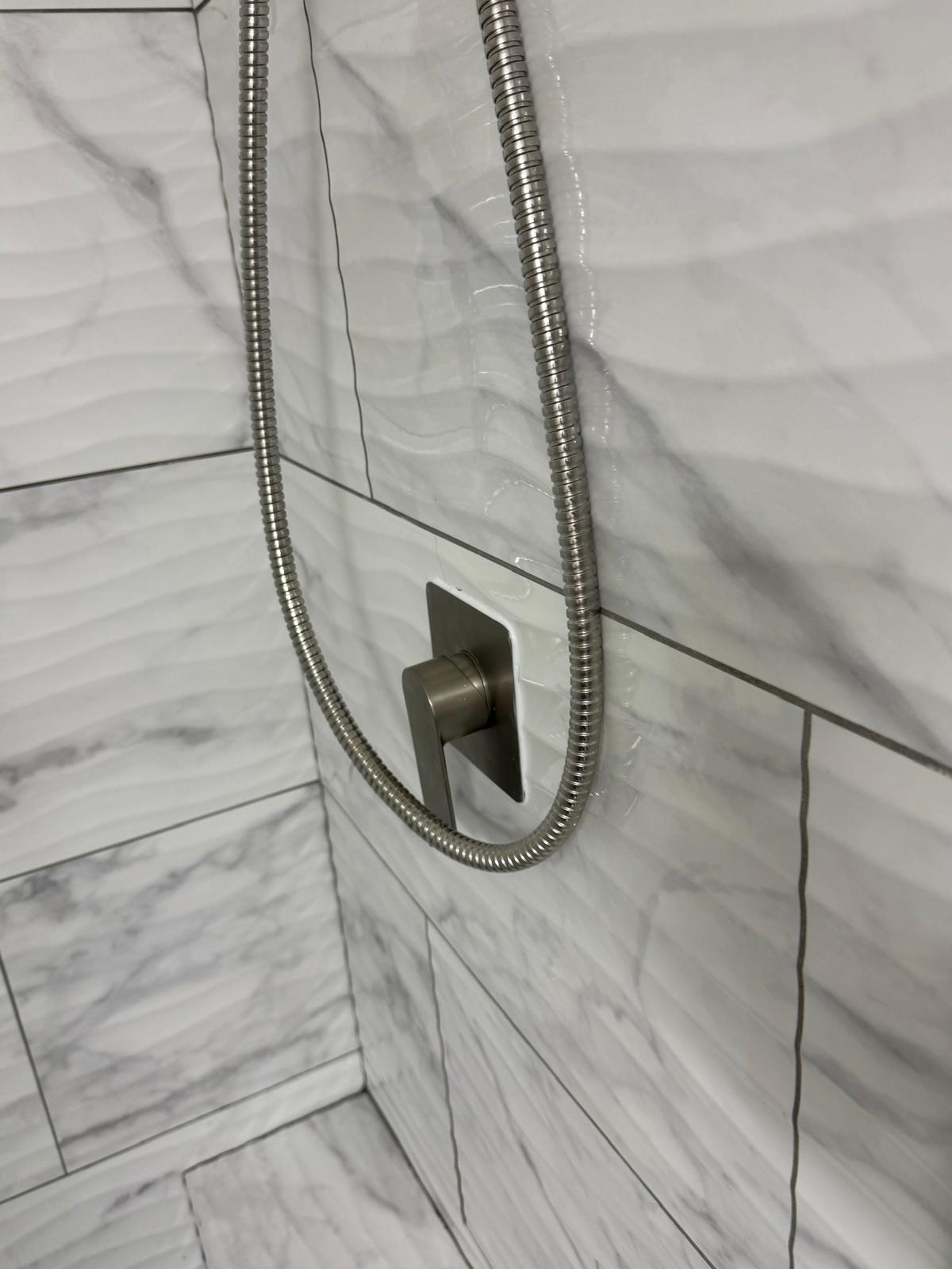 Brushed nickel shower valve on wave tile