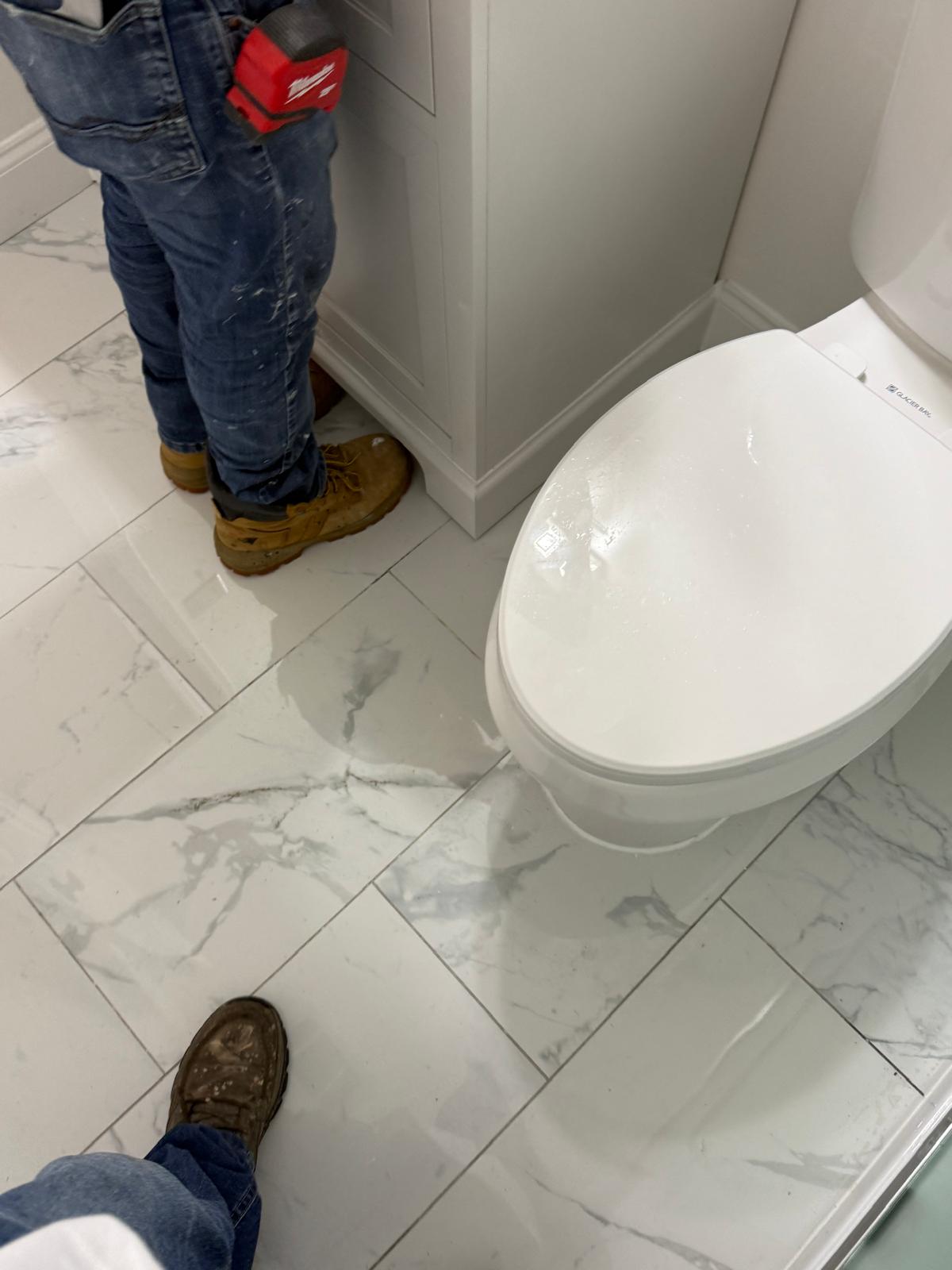 New toilet and vanity on marble-look porcelain floor