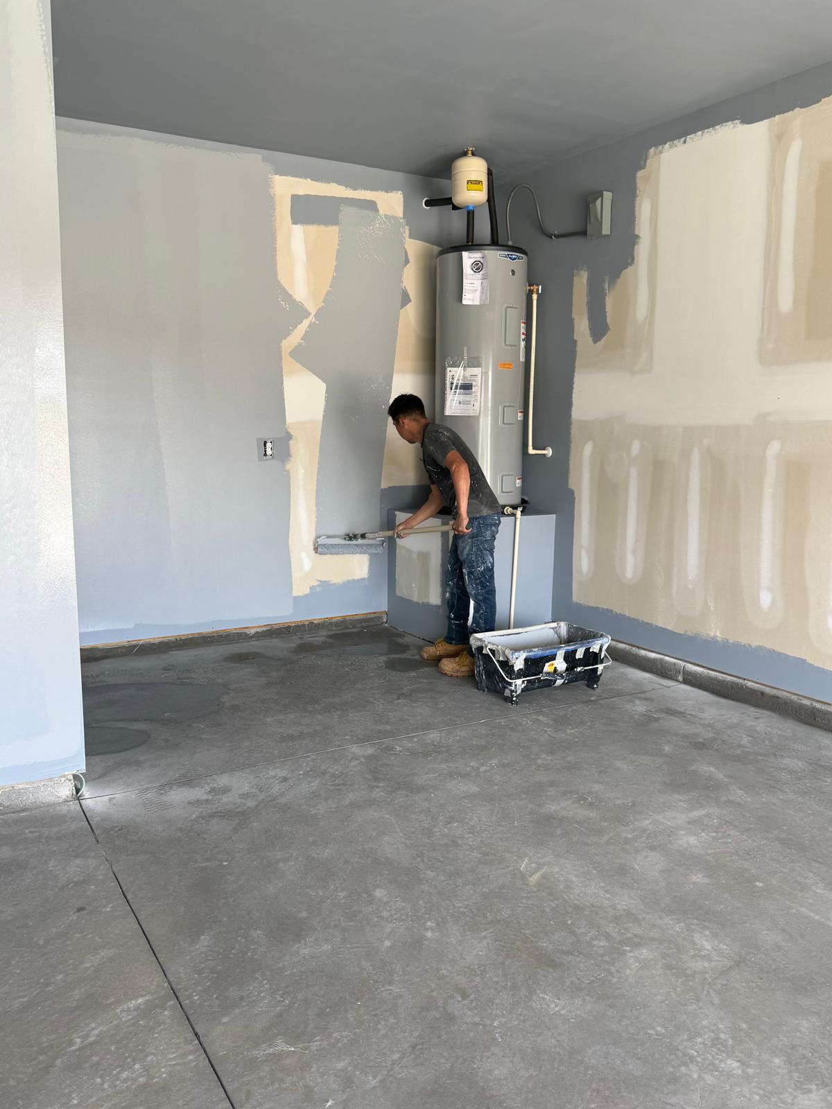 Painter rolling primer on the garage walls